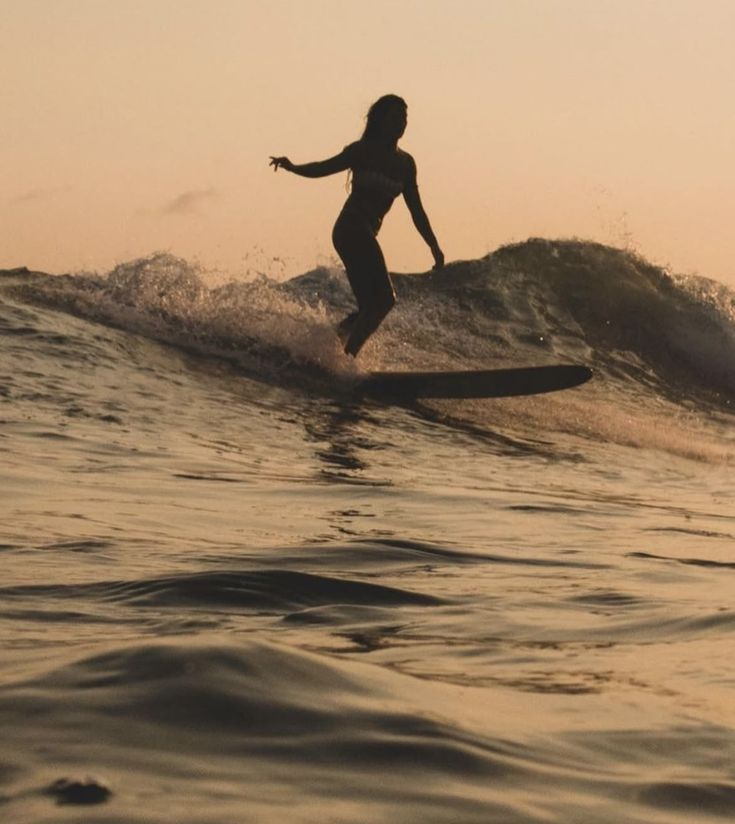 Surfer riding a wave at sunset in Santa Teresa