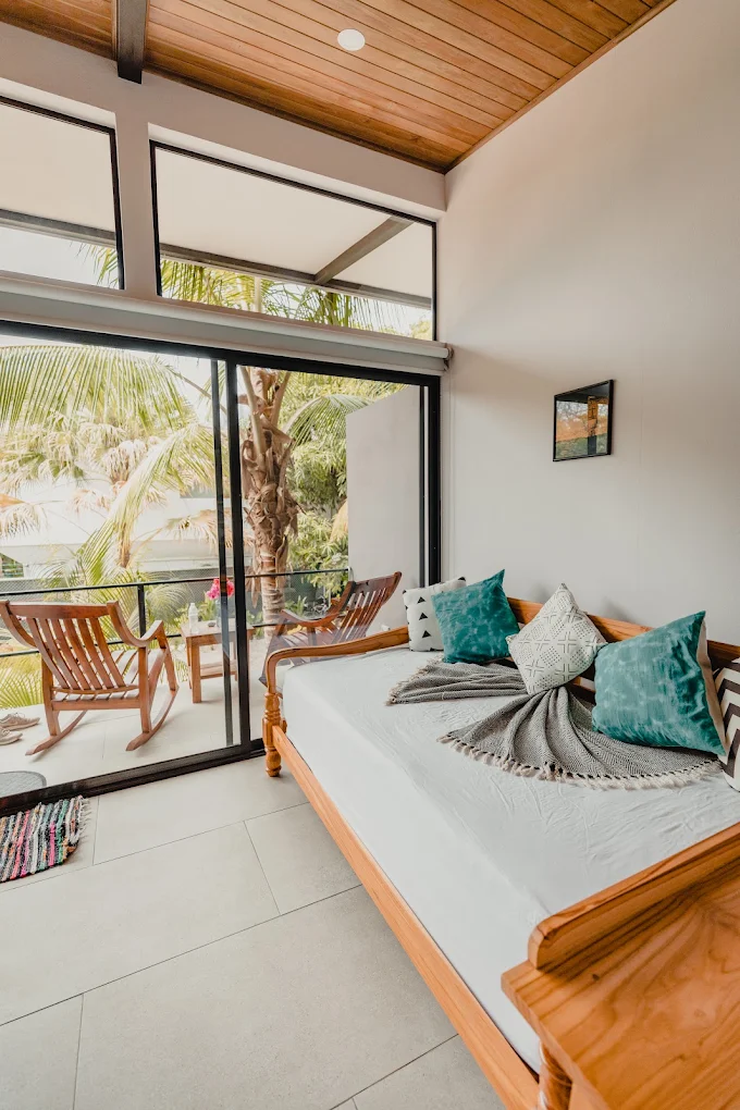 Bright shared room with a wooden daybed and balcony