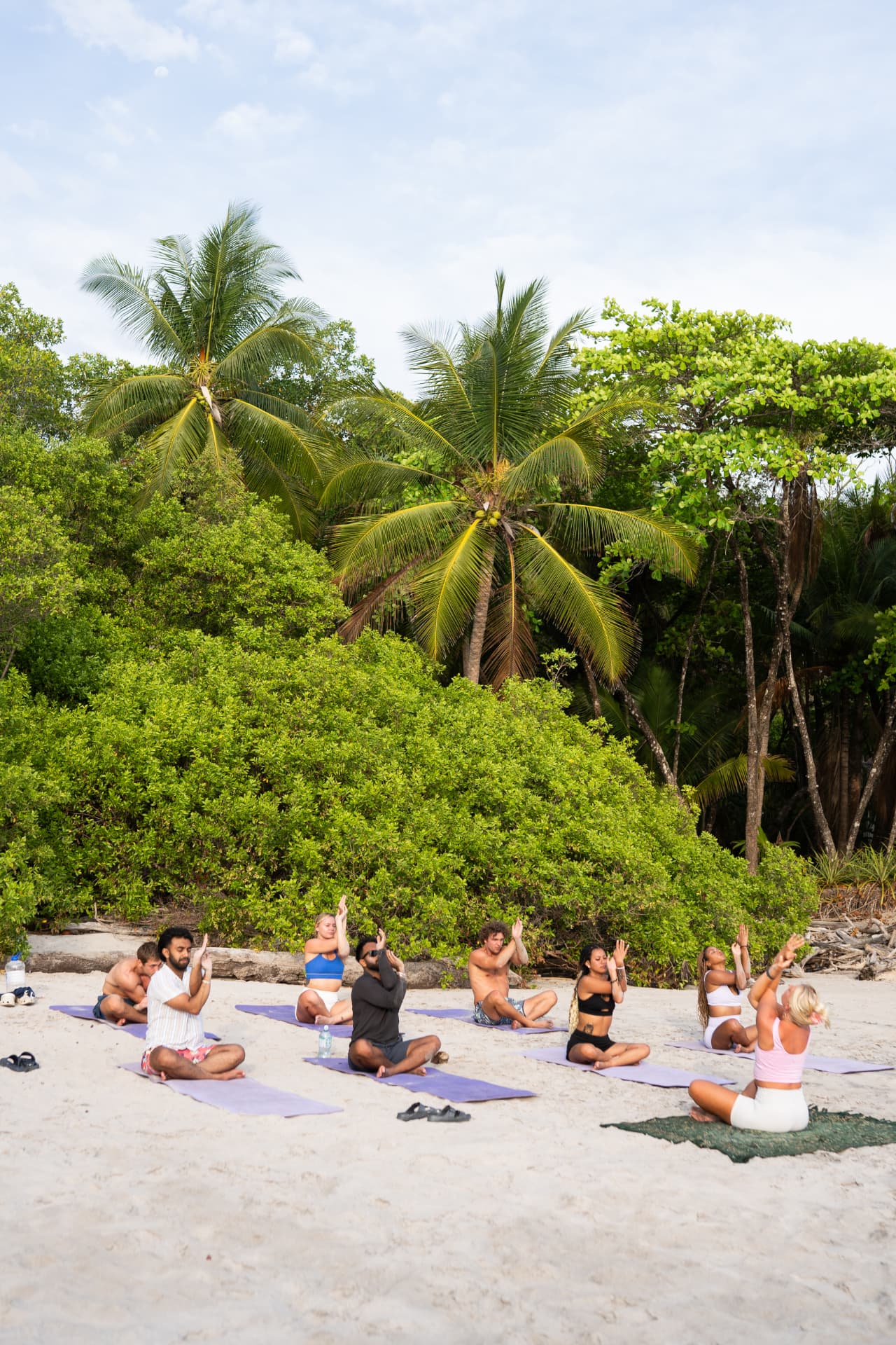 Group practicing yoga together on the beach