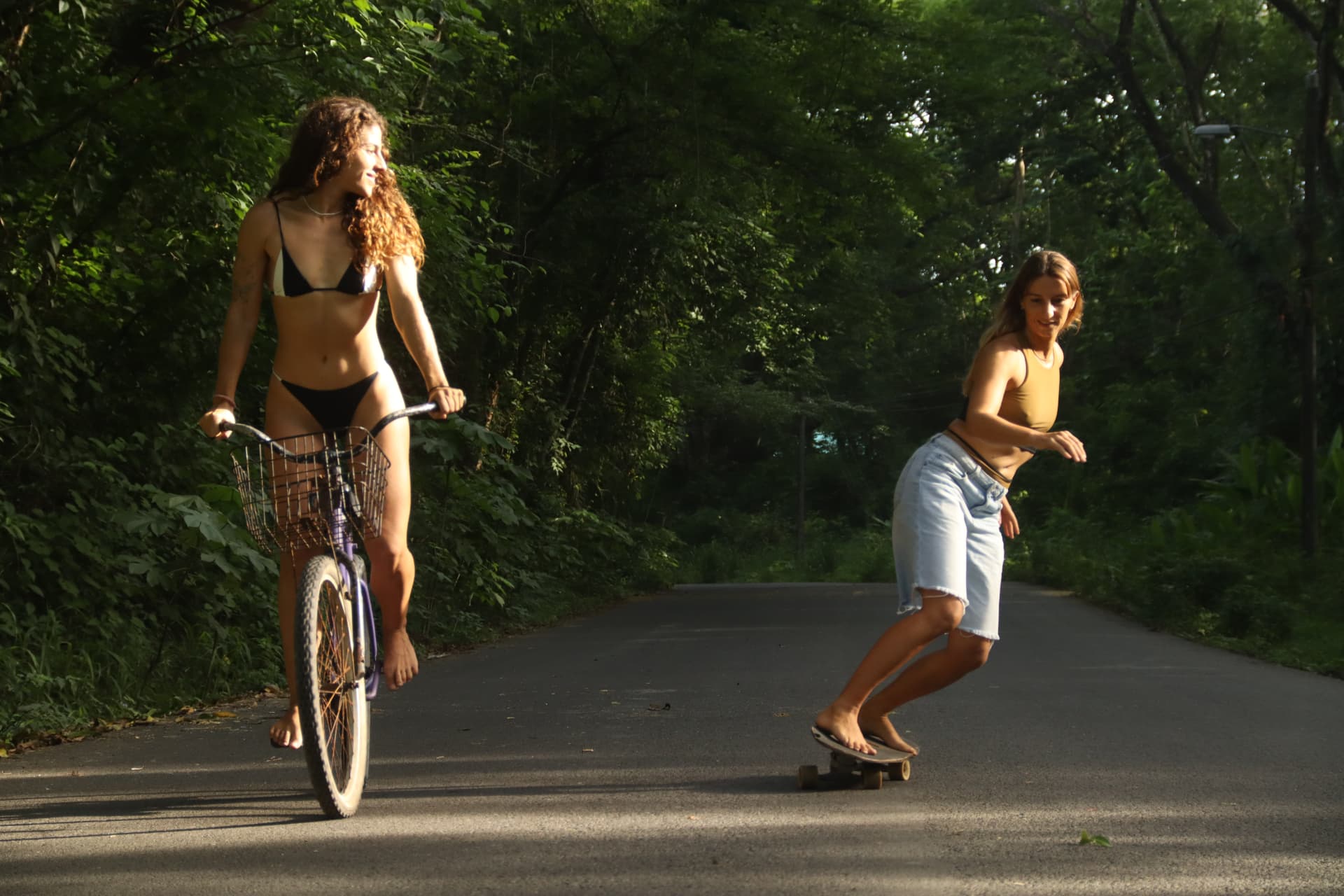 Friends biking and skating along a jungle road